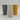 Three matte cylindrical cups or vases in dark gray, light beige, and mustard yellow, arranged in a row on a light gray studio background.