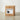 A brown cardboard shipping box with a white label reading 'CASE OF LINERS' and a black liner bucket illustration, standing on a light beige floor against a white wall.